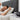 Mann im Bett, neben ihm CPAP-Maske und -Gerät bereit für die Reinigung mit einem CPAP-Reiniger.